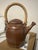 This vintage studio pottery teapot features a beautifully sculptural ribbed body finished in a warm iron-brown glaze with...