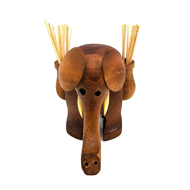 Offered is a mid 20th Century carved Teak wood elephant figurine with plastic tusks and eyes, and side saddle bags to hold...