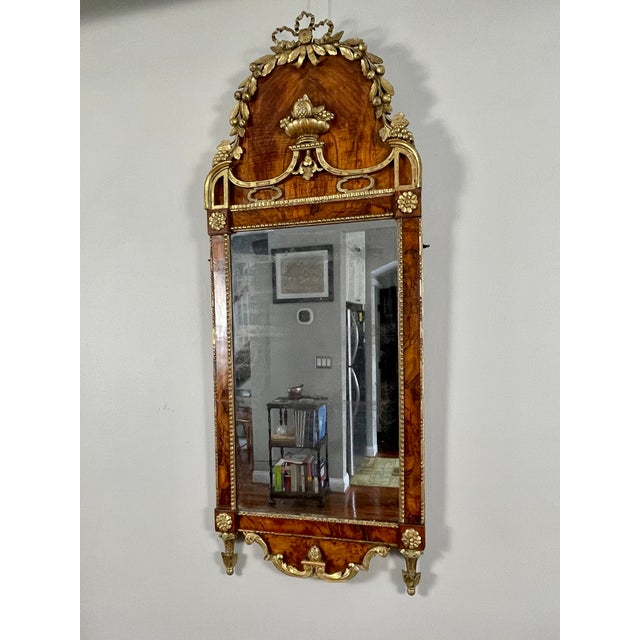 An elegant English pier mirror, likely dating from the third quarter of the 18th century, veneered in richly figured...