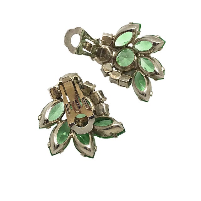 Here is a pair of identified 1960s D&E Juliana clip back earrings with green faceted and aurora borealis clear rhinestones...
