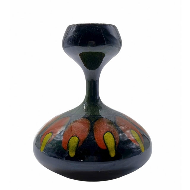 An elegant glazed ceramic vase, featuring an organic silhouette with a bulbous base and a tapered, goblet-shaped neck. The...
