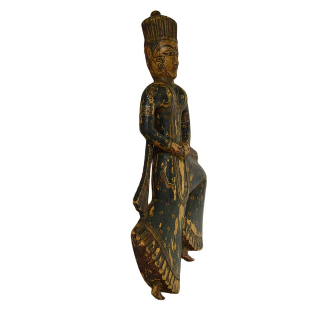 An antique temple statue carved and hand-painted in Indonesia in the early 20th century. This wooden statue shows an...