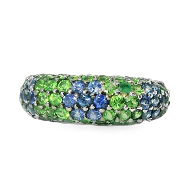 Exquisite 18K white gold cigar ring featuring 21 natural sapphires and 68 tsavorites (3 mm each). Comfortably sized at...