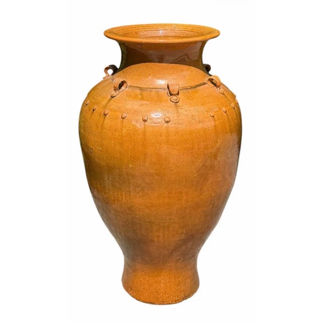 A monumental handcrafted glazed pottery floor vase inspired by traditional Martaban storage jars. Features a warm honey-...