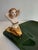 This charming vintage figural ashtray features a glamorous mermaid reclining along the edge of a sculptural emerald green...