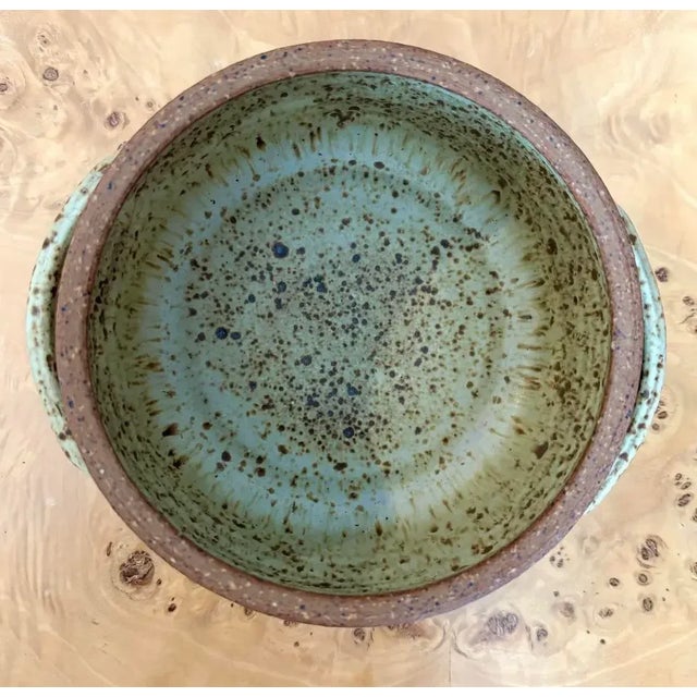 This stoneware vessel feels right at home on a rustic wooden dining table, where its speckled glaze echoes the grain of...