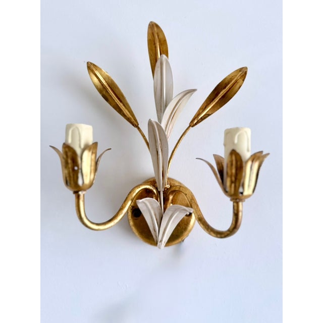 Italian gilt and white lacquered tôle two-light wall sconce attributed to Masca, 1970s. Hand-formed botanical leaves with...