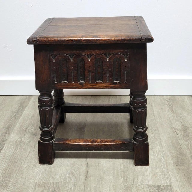 A late 19th-century English oak joint stool made in the 17th-century Gothic (Jacobean) revival style. The stool features a...