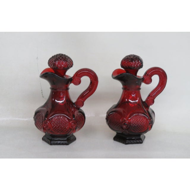 This lovely Set of Cruets Oil and Vinegar Bottles were made of glass. This Pair of Cruet is stamped on the bottom as being...