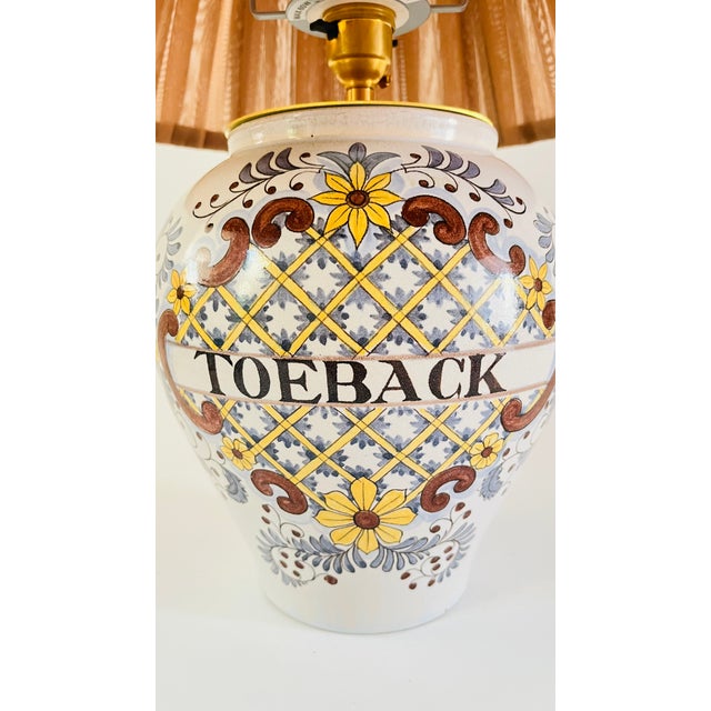 A mid 20th century table lamp made from a rare antique baluster tobacco vase. Decorated on a pale grey ground with hand...