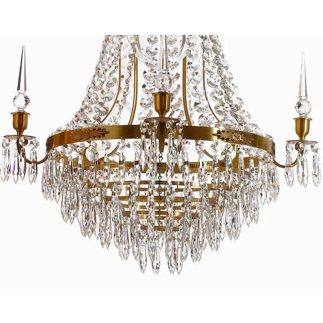 A large polished brass bathroom chandelier with hand cut crystals and oblisques and a crystal drop bottom. The light bulb...