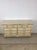 This mid century French Provincial style lowboy dresser features painted white finish, ornate brass hardware, and sculpted...