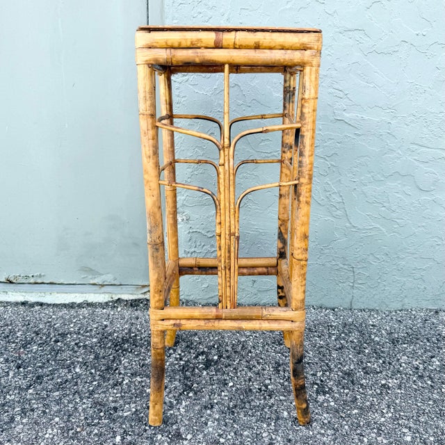 Vintage bamboo pedestal or plant stand featuring a warm natural finish accented by distinctive burnt tortoise detailing...