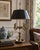 A classic bouillotte lamp rendered in warm brass, distinguished by its sculptural four-arm base and clean, tailored black...