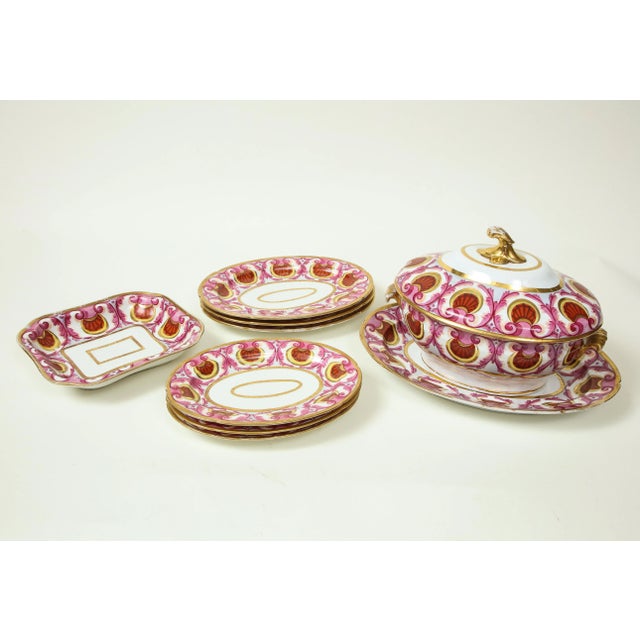 Each boldly painted with a border of iron-red shells and pink foliage, comprising a soup tureen, cover and stand, a...