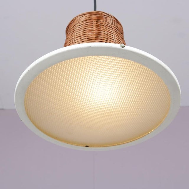 1950s set of 2 hanging lamps in wicker, black metal, and glass. These lamps reflect mid-century design sensibilities,...