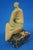 Item description: Terracotta sculpture entirely modeled by hand without a mold, depicting a stylized seated woman....