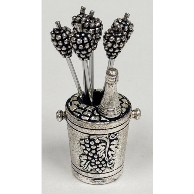 Spanish silver tone metal set of six (6) olive picks in charming grape and wine bucket motif holder. Picks measure 3.5"L....