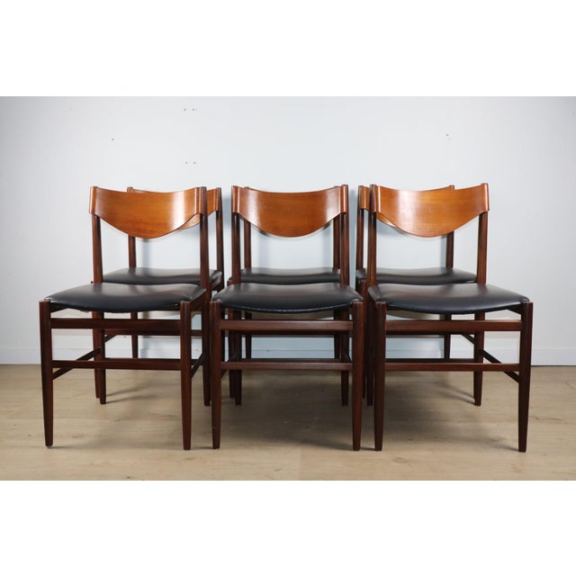 An elegant set of six chairs designed by Gianfranco Frattini in the 1960s, combining a slender teak frame with black vinyl...