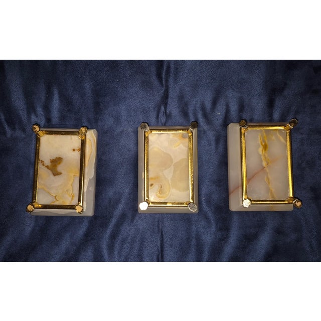 This is a set of three rectangular, hand-carved white/translucent alabaster or onyx stone dishes or small trays, featuring...