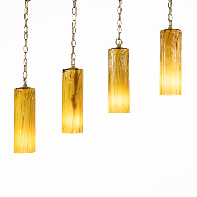 Set of four mid-century Murano tubular pendant lights in richly layered amber and white “incamiciato” glass, inspired by...
