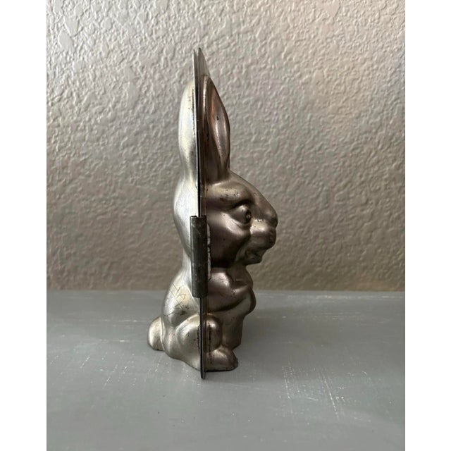 Charming vintage two-piece metal confectionery mold featuring a dimensional seated rabbit with long upright ears,...