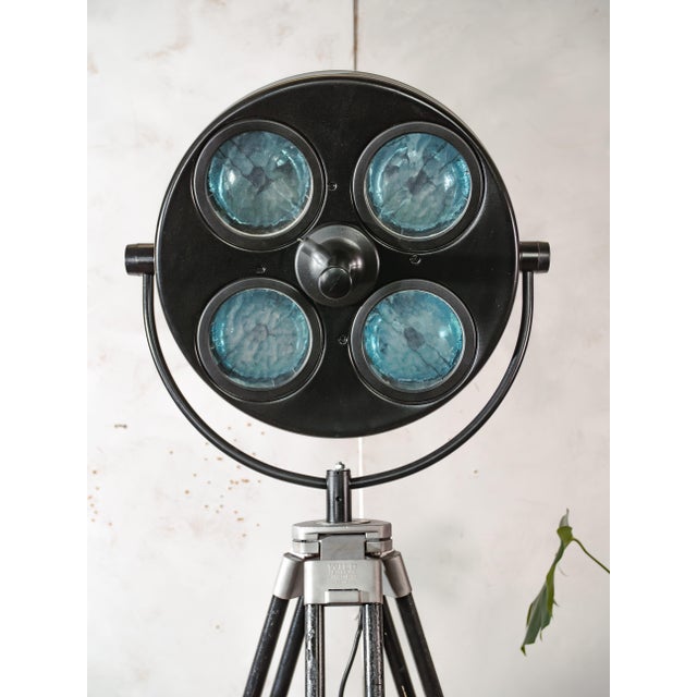 A 1960s hanau surgical lamp with four blue glass lenses, reworked into a floor lamp and mounted on a wild heerbrugg wooden...