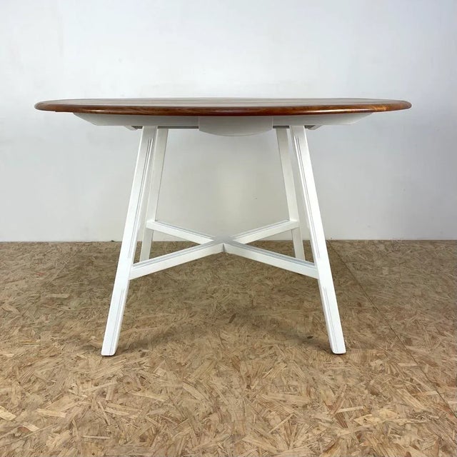 Mid century vintage drop leaf dining table manufactured in the England during the 1960s by Ercol. The solid elm top has...