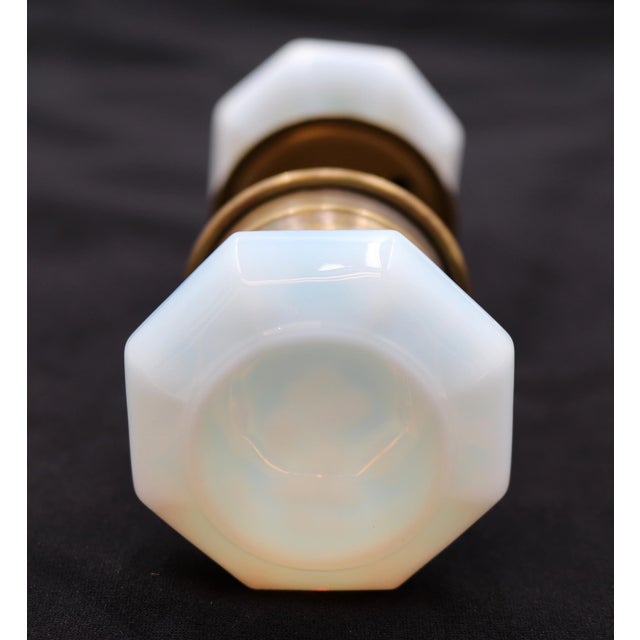 Octagon shaped iridescent milk glass door knobs with a wide brass shank and rosettes. Good condition with appropriate wear...