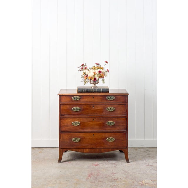 This George III mahogany chest of drawers features four graduated drawers, framed by cockbeaded edges and adorned with...