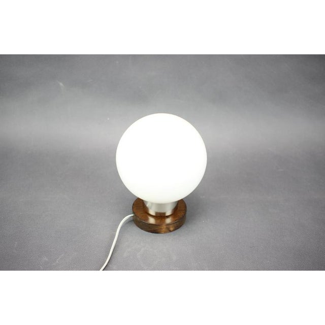 Vintage table lamp produced by Pokrok Žilina in Czechoslovakia during the 1960s. The lamp features a white opaline glass...
