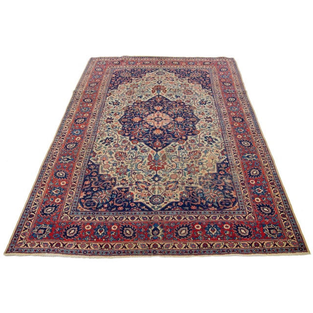 This beautifully handcrafted Persian Tabriz wool rug displays a classic floral pattern. The contrast created by the blue...