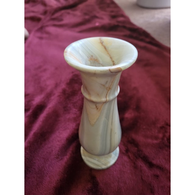 This neoclassical marble vase consists of various shades of cream throughout the piece. The vase is substantial in weight...