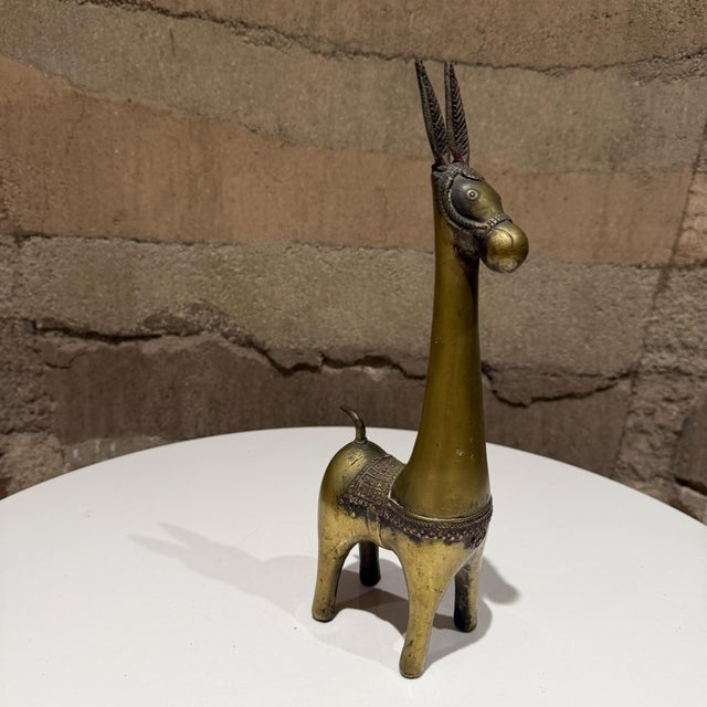 For your consideration, a vintage brass figurine of a stylized animal, often identified as a llama, burro, or donkey,...