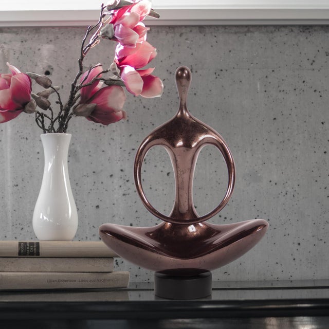 This stature is fashioned from wood into an abstract figure sitting in a yoga pose. It is then finished in a glossy pewter...