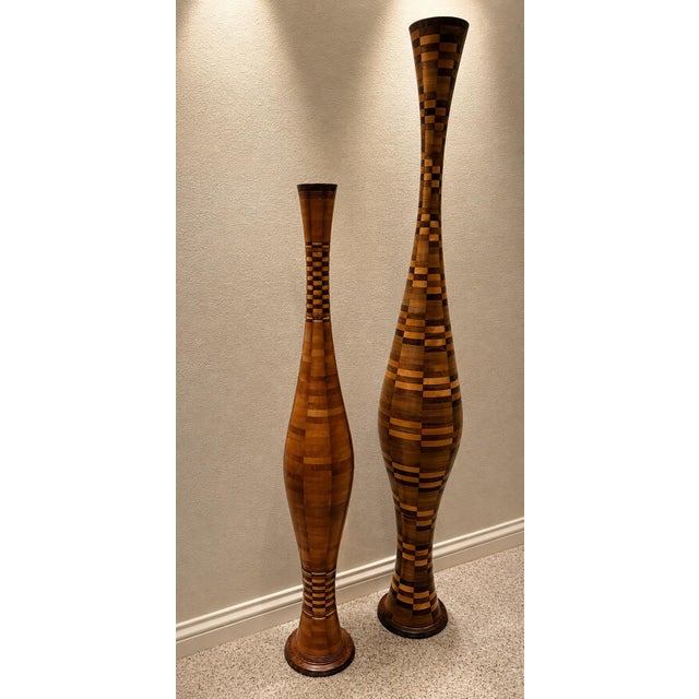 A elegant pair of handcrafted segmented wood floor vases showcasing exceptional craftsmanship and sculptural design. Each...