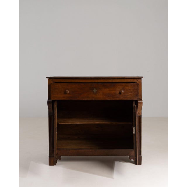 This piece presents as a side cabinet, distinguished by dark mahogany, single drawer, open shelf. It was made in France...