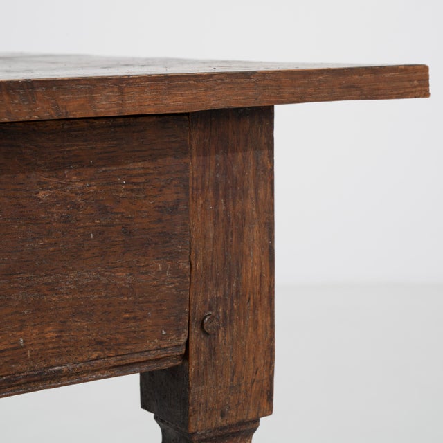 A French side table in the Louis XVI style, dating to circa 1800, featuring a structured wooden frame with balanced...