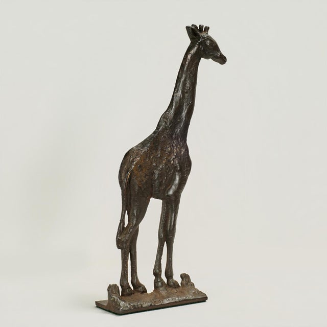 Standout antique cast iron door stop in the form of a giraffe with a bronze like finish.