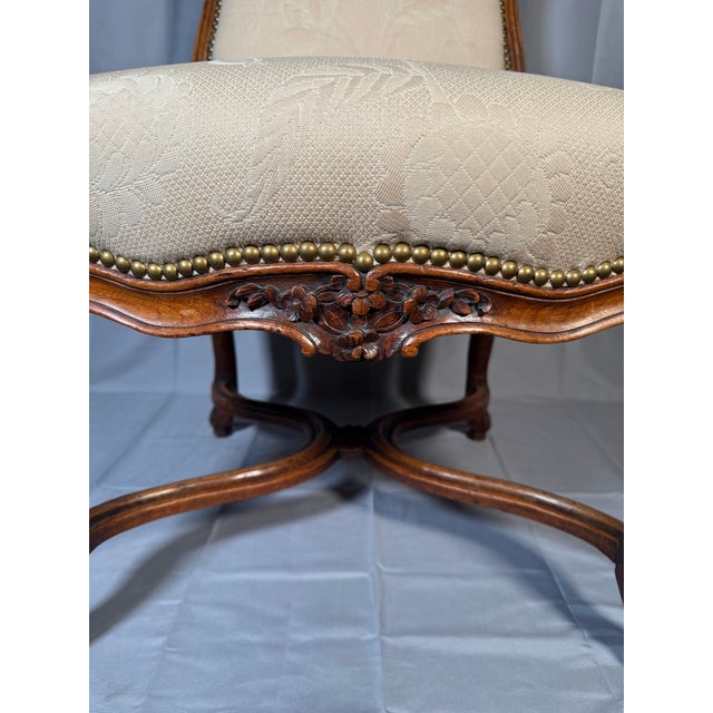 • Material: Carved walnut frame, upholstered seat and back • Dimensions: Approx. 37 in high; seat approx. 17-18 in wide x...