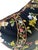 This pillow showcases a vibrant botanical pattern of flowers and birds against a dark background, creating a striking...