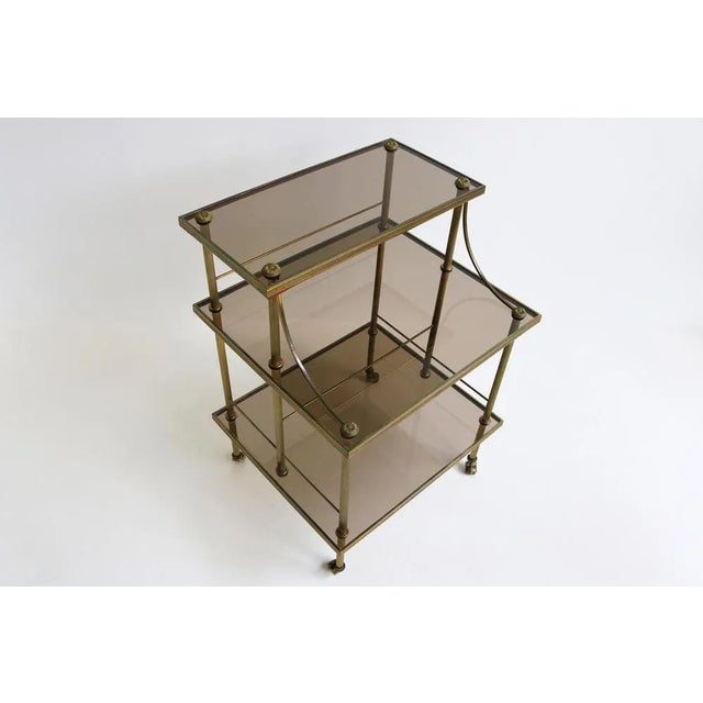 Jewel of a high quality brass and smoked glass serving trolly on castors in Maison Jansen , Maison Baguès Style. Made in...