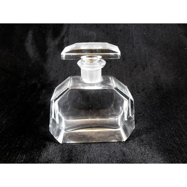 This is a cut crystal perfume bottle with a matching stopper. The bottle is rectangular shaped with cut off corners and a...