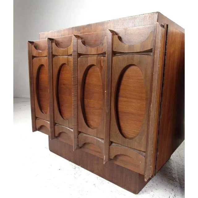 This midcentury pair of sculpted front nightstands adds distinctive brutalist modern style and spacious bedside storage....