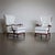 Pair of armchairs on polished wooden frames and cushioned seats with high wingbacks and upholstered armrests. The...