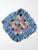 Vintage yo-yo quilted pillow cover featuring colorful floral fabric yo-yos arranged on a blue cotton ground with a large...