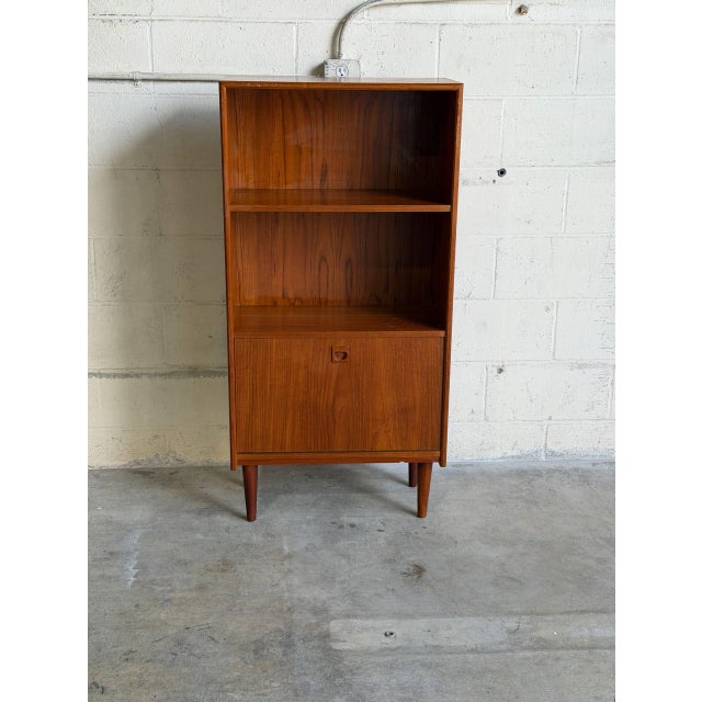 Vintage Danish modern bookcase cabinet crafted in richly grained teak with clean Scandinavian lines and elegant tapered...