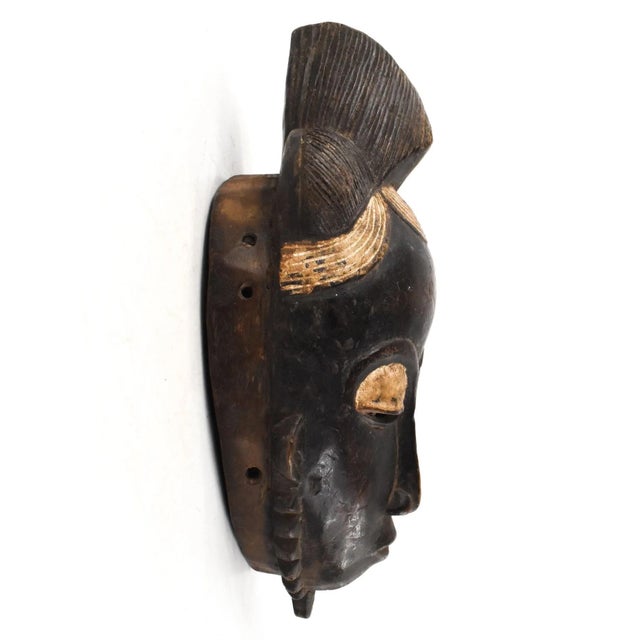 This mask has a much elaborated coiffure typical of the Baule and Yaure. The facial features of masks from these two...