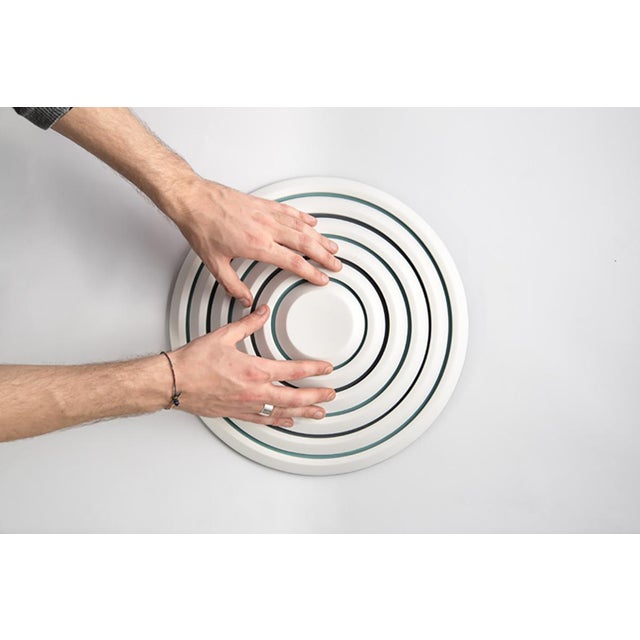 Metal sheets and shaped corian rings interlock, fix, and attract each other, creating surface tension. A collection of...