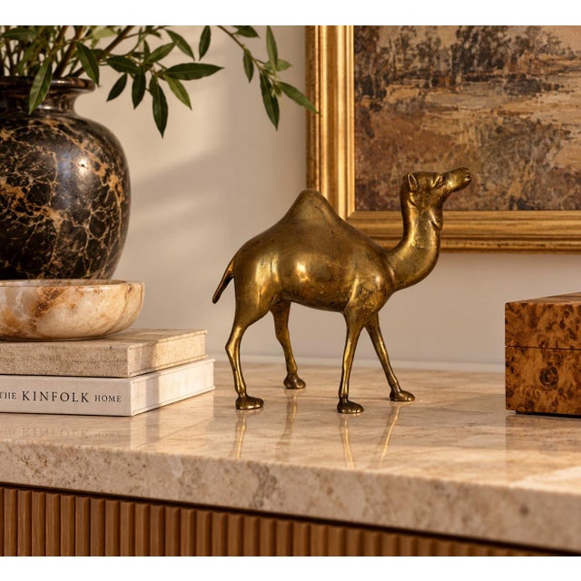 Beautiful vintage 1980s brass camel sculpture featuring an elegant, sculptural silhouette with a single hump, elongated...